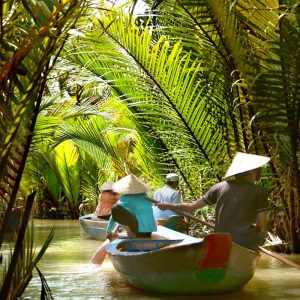 Experience a serene riverboat journey through lush tropical palms in Ho Chi Minh City, Vietnam.